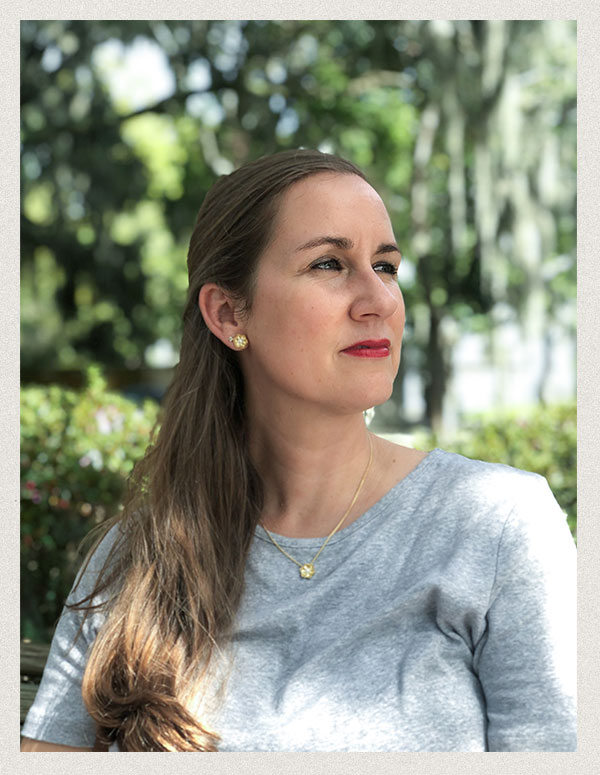 Copy editor, Julie Reibsamen sitting under trees and looking off to the distance.